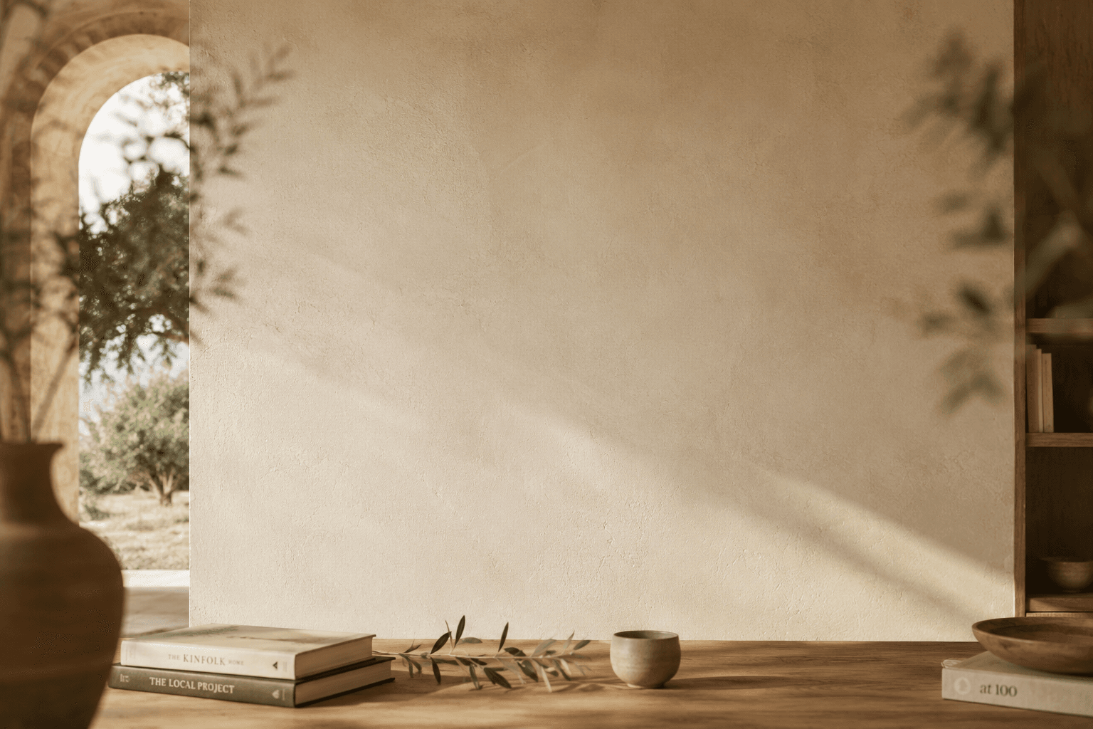 Interno mediterraneo con parete in calce, ulivo e libri